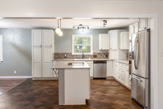 kitchen with a kitchen island, sink, white cabinets, pendant lighting, and appliances with stainless steel finishes