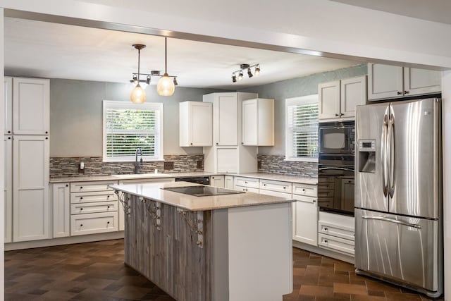 kitchen with white cabinetry, black appliances, and a kitchen island