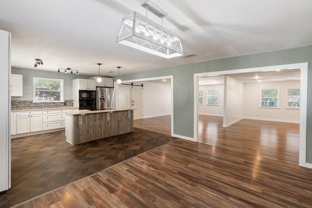 kitchen with a kitchen island, a barn door, and dark hardwood / wood-style floors