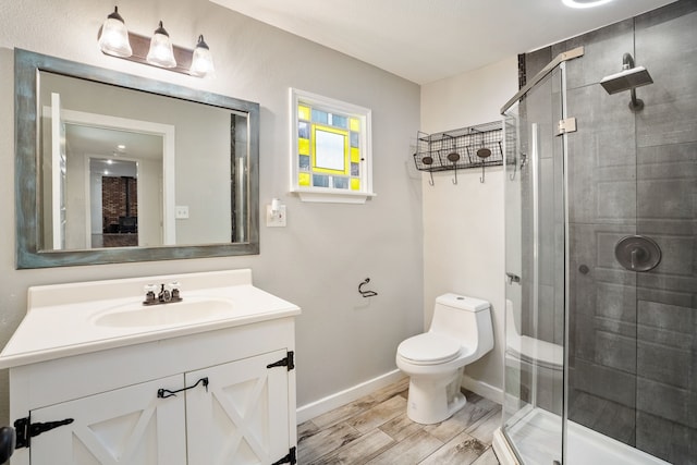 bathroom featuring toilet, a shower with shower door, hardwood / wood-style flooring, and vanity