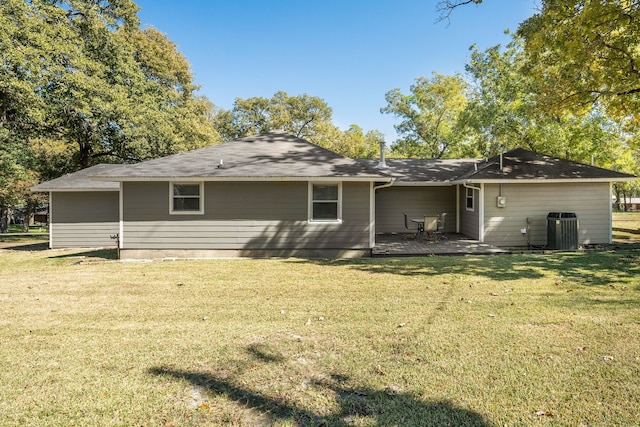 rear view of property featuring a yard, a patio, and central AC unit