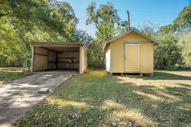 view of outdoor structure with a yard and a carport