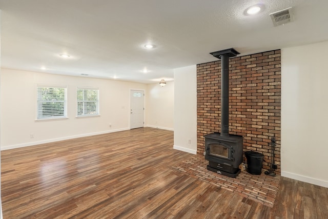 unfurnished living room with a textured ceiling and dark hardwood / wood-style flooring