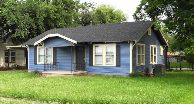 view of front of house with central AC and a front lawn