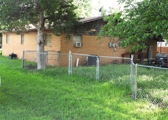 view of side of property featuring a yard, cooling unit, and central air condition unit