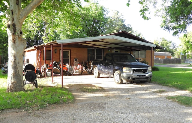 view of parking / parking lot with a yard and a carport