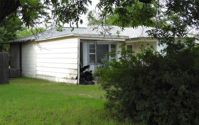 view of home's exterior featuring cooling unit and a lawn