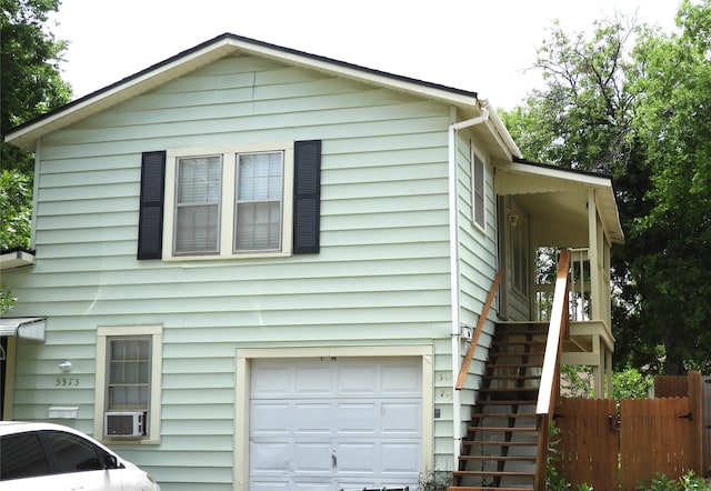 view of property exterior with cooling unit and a garage