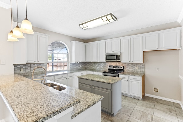 kitchen with backsplash, white cabinetry, stainless steel appliances, pendant lighting, and a center island