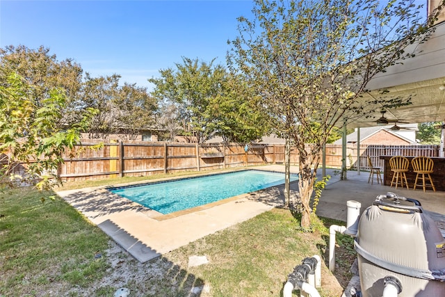 view of swimming pool with a yard, ceiling fan, and a patio area