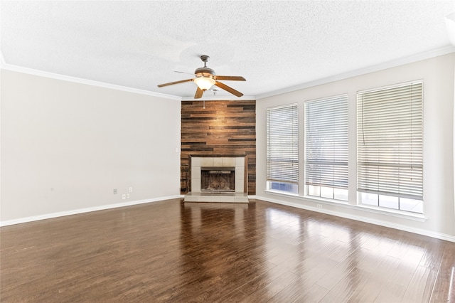 unfurnished living room with dark wood-type flooring, a tiled fireplace, a textured ceiling, and ceiling fan