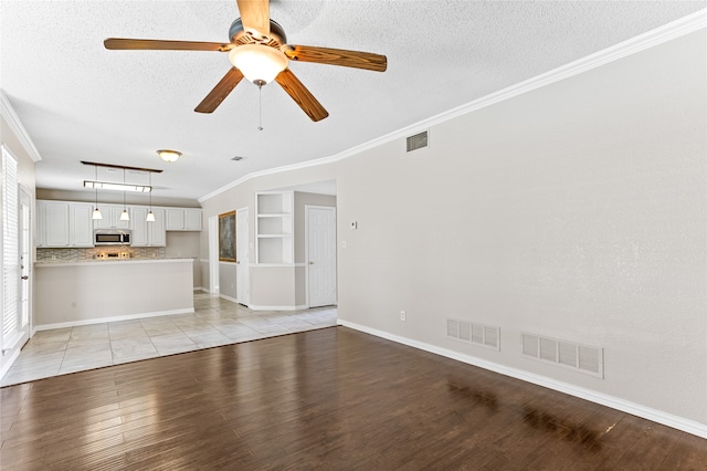 unfurnished living room featuring crown molding, a textured ceiling, light hardwood / wood-style flooring, and ceiling fan