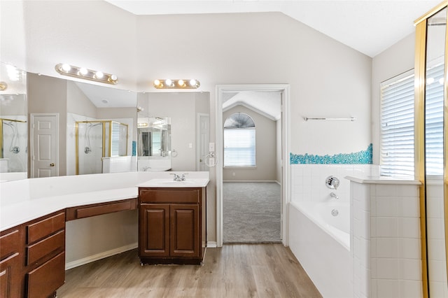 bathroom with vanity, hardwood / wood-style flooring, independent shower and bath, and vaulted ceiling