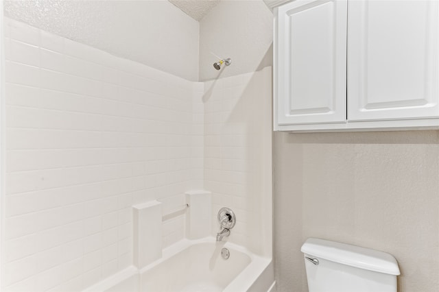 bathroom featuring toilet, a textured ceiling, and shower / tub combination