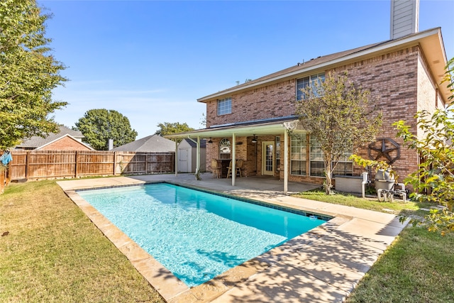 view of pool featuring a patio, a storage unit, and a yard