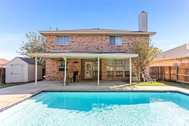 view of swimming pool with a patio area and a shed