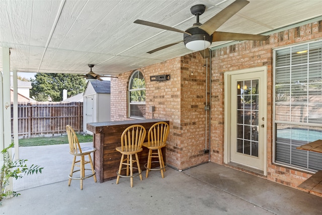 view of patio / terrace featuring a storage unit, a bar, and ceiling fan