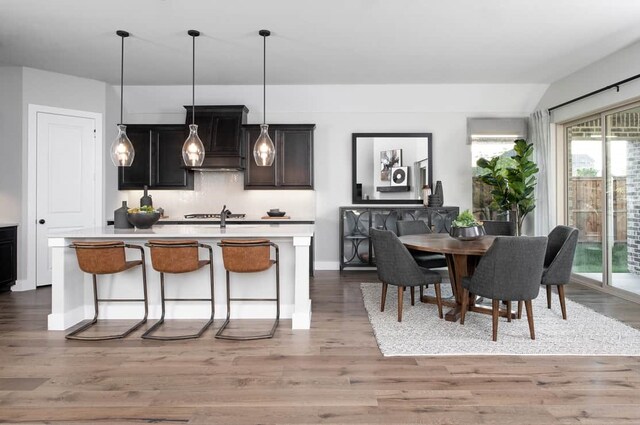 4127 Olmsted Dr, Rockwall, TX 75032 - kitchen with a kitchen breakfast bar, decorative light fixtures, light wood-type flooring, and an island with sink