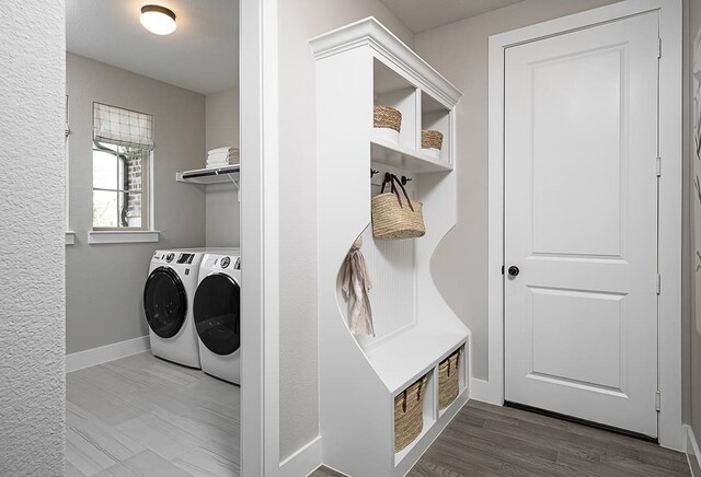 laundry room with washer and dryer and wood-type flooring