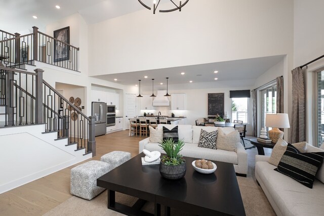 4127 Olmsted Dr, Rockwall, TX 75032 - living room featuring an inviting chandelier, sink, a high ceiling, and light wood-type flooring