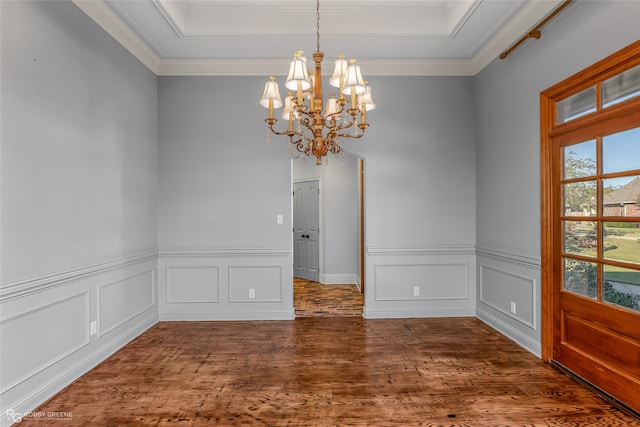 spare room with dark wood-type flooring, crown molding, and a chandelier