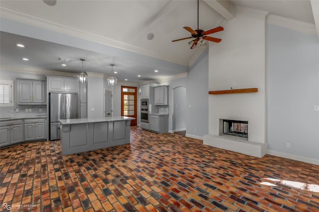 kitchen featuring stainless steel appliances, ornamental molding, a center island, pendant lighting, and gray cabinets