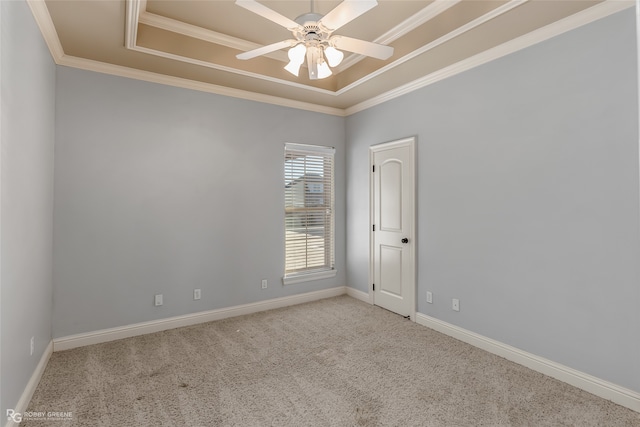 empty room with ornamental molding, light colored carpet, a tray ceiling, and ceiling fan