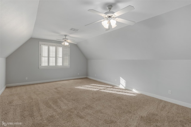 additional living space with ceiling fan, vaulted ceiling, and light colored carpet