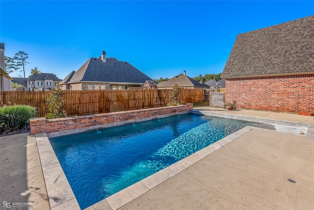 view of swimming pool with pool water feature and a patio