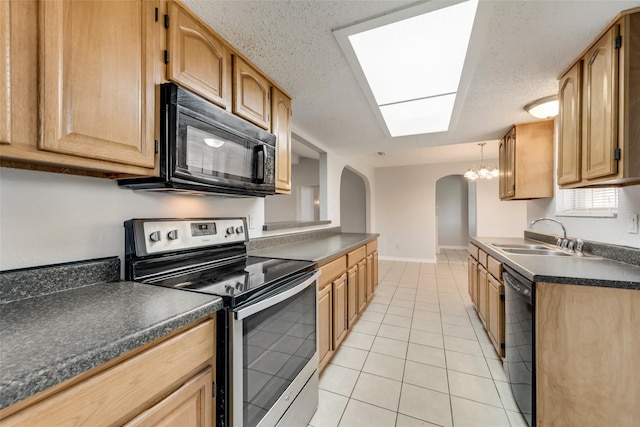 kitchen featuring light tile patterned floors, an inviting chandelier, a textured ceiling, black appliances, and sink