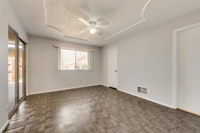 spare room with dark parquet floors, a textured ceiling, and ceiling fan