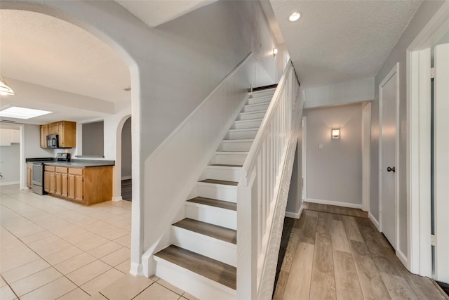 stairway featuring a textured ceiling and hardwood / wood-style flooring