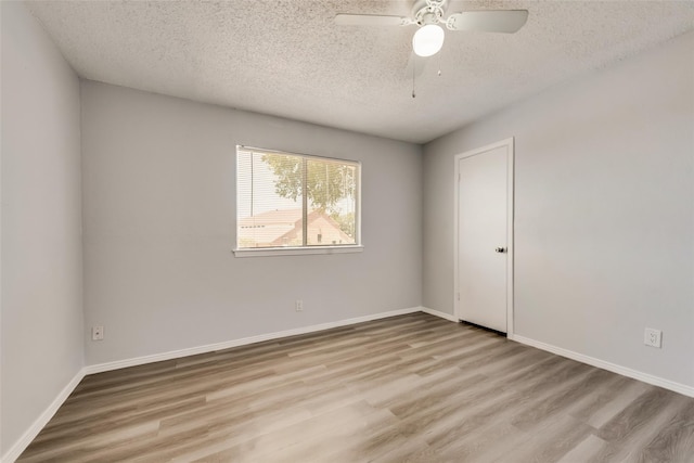 spare room with a textured ceiling, light hardwood / wood-style floors, and ceiling fan