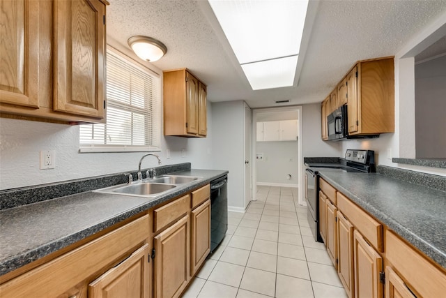 kitchen with sink, black appliances, a textured ceiling, and light tile patterned floors