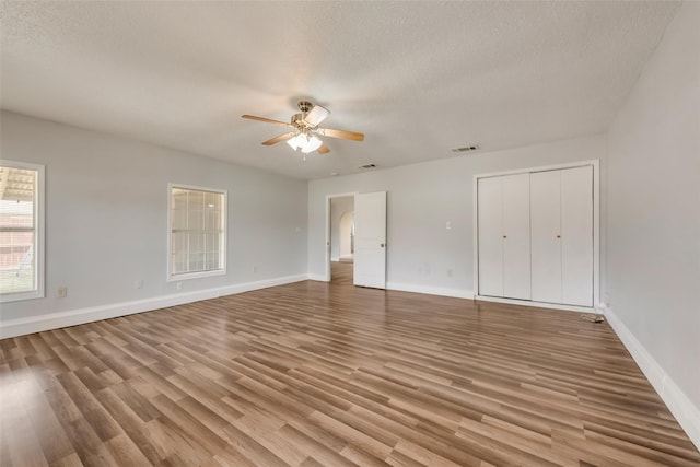 unfurnished bedroom featuring light hardwood / wood-style floors, a textured ceiling, and ceiling fan