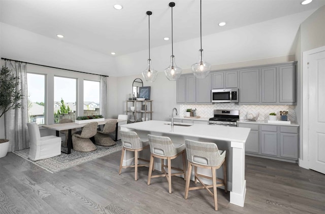 kitchen with sink, appliances with stainless steel finishes, decorative light fixtures, and gray cabinetry