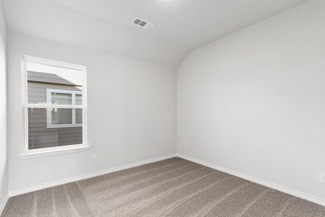 unfurnished room featuring vaulted ceiling and carpet