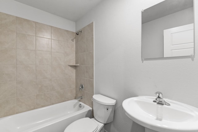 full bathroom with sink, tiled shower / bath combo, and toilet