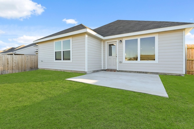 back of property with a patio area and a lawn