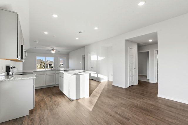 kitchen featuring a center island, stove, dark hardwood / wood-style floors, gray cabinets, and ceiling fan