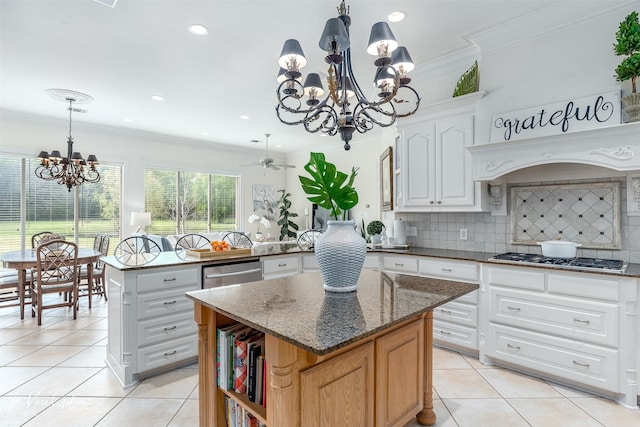 kitchen with a kitchen island, white cabinetry, dark stone counters, pendant lighting, and stainless steel appliances