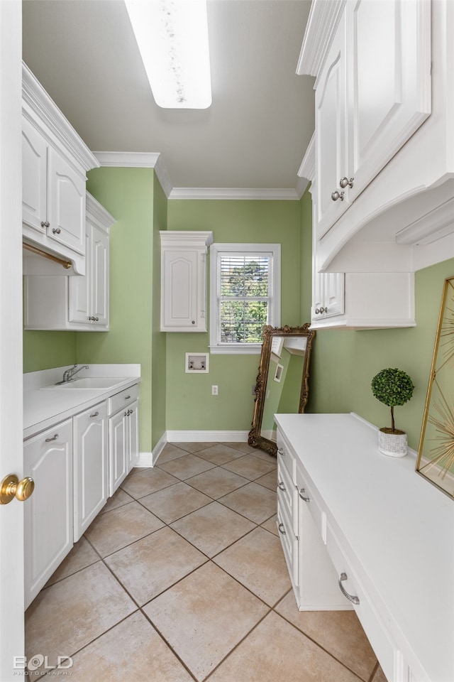 washroom featuring hookup for a washing machine, ornamental molding, sink, light tile patterned floors, and cabinets