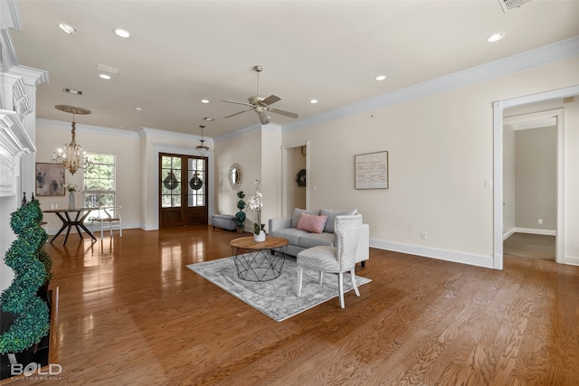 living room featuring french doors, crown molding, ceiling fan with notable chandelier, and hardwood / wood-style floors