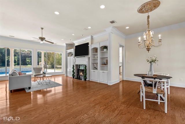 living room with ornamental molding, hardwood / wood-style flooring, and ceiling fan with notable chandelier