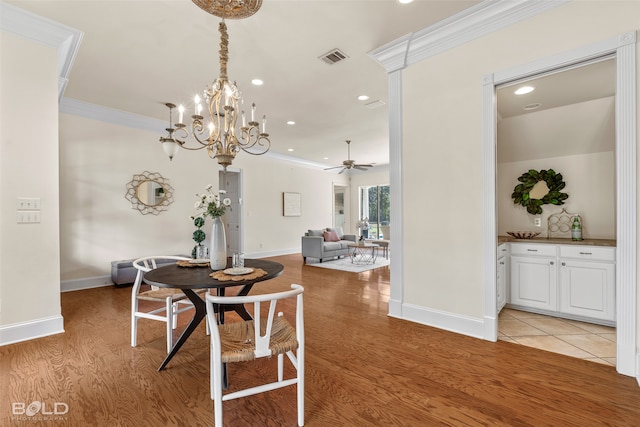 dining room featuring light hardwood / wood-style floors, crown molding, and ceiling fan with notable chandelier