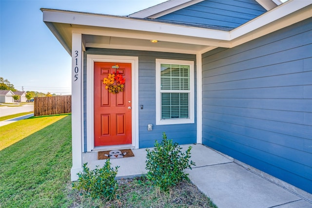 property entrance featuring a lawn