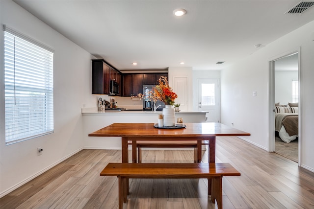 dining area with a wealth of natural light and light hardwood / wood-style floors