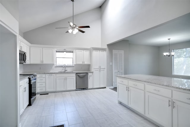 kitchen with light stone counters, stainless steel appliances, high vaulted ceiling, and white cabinets