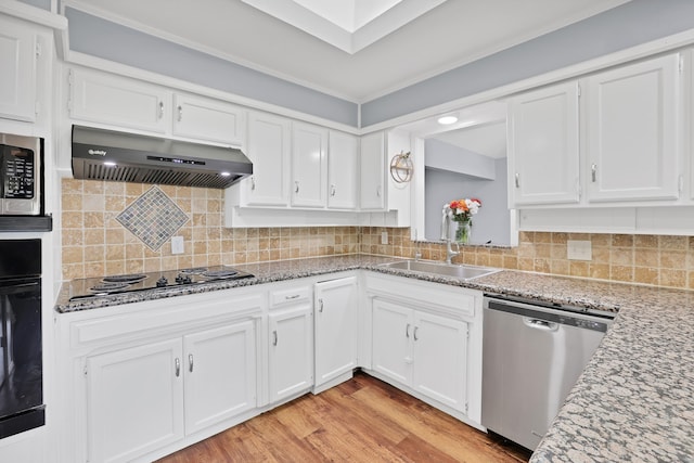 kitchen with ventilation hood, white cabinets, sink, light hardwood / wood-style floors, and stainless steel appliances