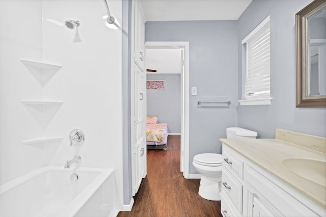 full bathroom featuring hardwood / wood-style floors, vanity, toilet, and shower / bathtub combination